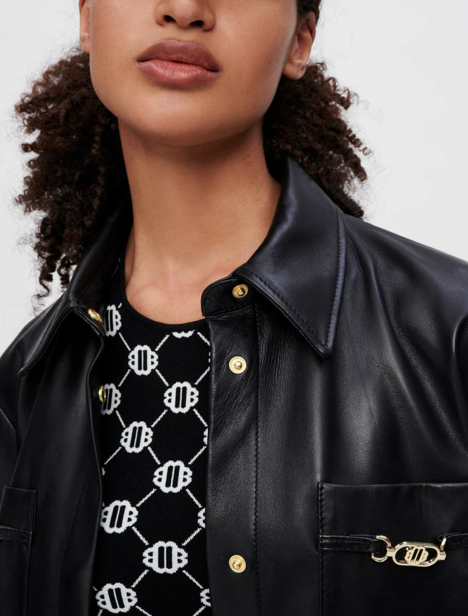 Chemise en cuir noir à mors dorés